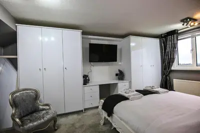 a bedroom with a bed and a chair and a television at Family Escape, Blackpool Attractions Nearby coast in Poulton le Fylde