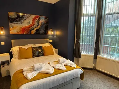 a bedroom with a bed with towels on it at Louise Suite in Southport