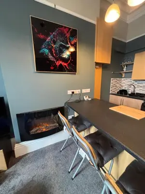 a living room with a fireplace and a table and chairs at Louise Suite in Southport
