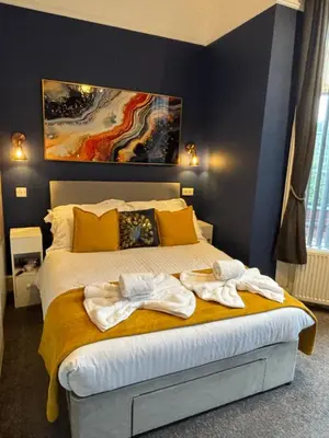 a bedroom with a bed with towels on it at Louise Suite in Southport