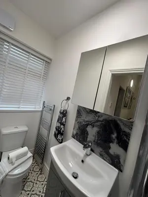 a bathroom with a sink and a toilet and a mirror at Louise Suite in Southport