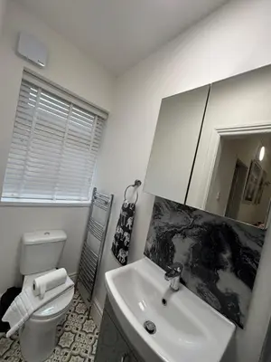 a bathroom with a sink and a toilet and a mirror at Louise Suite in Southport