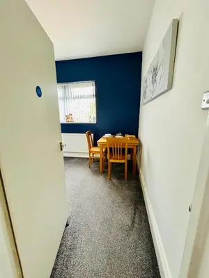 a dining room with a table and a blue wall at Michaels Suite in Southport