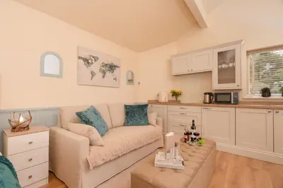 a living room with a couch and a kitchen at Ribblesdale Cottage in Acres of Countryside in Chatburn
