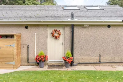a house with two potted plants on the front door at Ribblesdale Cottage in Acres of Countryside in Chatburn