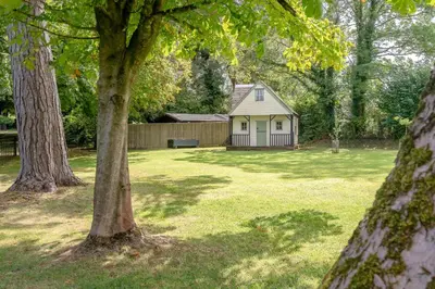 a small house in the middle of a yard with trees at Ribblesdale Cottage in Acres of Countryside in Chatburn