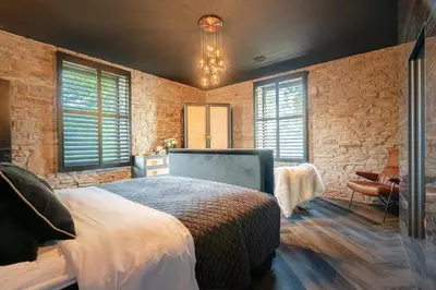 a bedroom with a bed and a stone wall at Brierley Club Hideaway Chic 7 Star Retreat in Rishton
