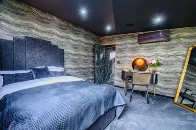 a bedroom with a large bed and a table with a mirror at Brierley Club Hideaway Chic 7 Star Retreat in Rishton