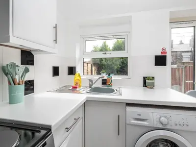 a white kitchen with a sink and a dishwasher at Pass the Keys Cosy Liverpool Home. WiFi Parking Nr Alder Hey in Liverpool
