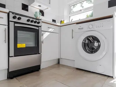 a kitchen with a washing machine and a washer at Pass the Keys Cosy Liverpool Home. WiFi Parking Nr Alder Hey in Liverpool