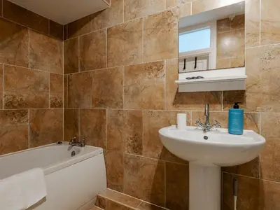 a bathroom with a sink and a bath tub at Pass the Keys Cosy Liverpool Home. WiFi Parking Nr Alder Hey in Liverpool