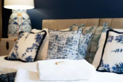 a close up of a bed with blue and white pillows at Luxury Waterfront Apartment - Liverpool City Centre - Sleeps 4 in Liverpool