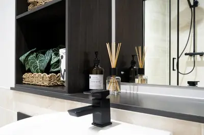 a bathroom with a sink with bottles of wine at Luxury Waterfront Apartment - Liverpool City Centre - Sleeps 4 in Liverpool