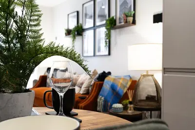 a wine glass sitting on a table in a living room at Luxury Waterfront Apartment - Liverpool City Centre - Sleeps 4 in Liverpool