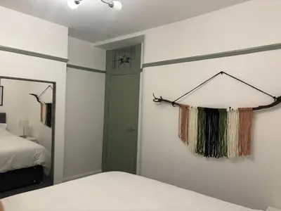 a bedroom with a bed and a door with a curtain at The Bohe Home in Wallasey
