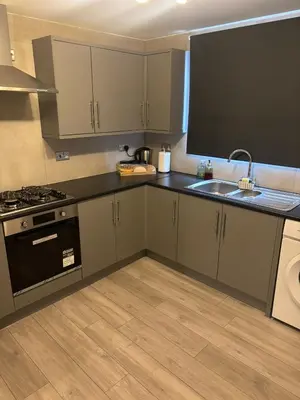 a kitchen with a sink and a stove at The Bohe Home in Wallasey
