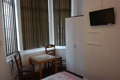 a room with a table and two chairs and a television at Cardoh Lodge in Blackpool