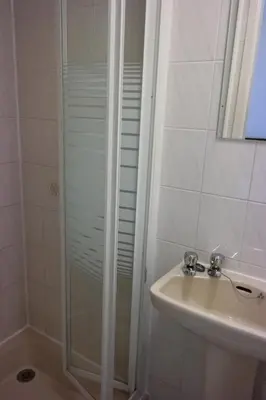 a bathroom with a shower and a sink at Cardoh Lodge in Blackpool