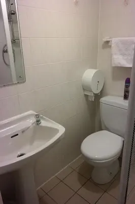 a white bathroom with a toilet and a sink at Cardoh Lodge in Blackpool