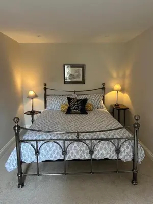a bed in a bedroom with two lamps on two tables at The Tractor House in Great Urswick
