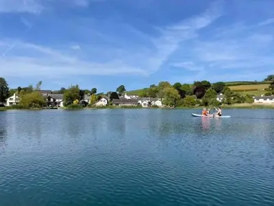 two people are in a boat on a lake at The Tractor House in Great Urswick
