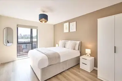 a white bedroom with a large bed and a window at 2 Bed - Sleeps 6 - Parking - City Centre in Liverpool