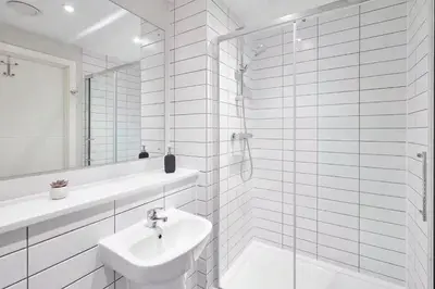 a white bathroom with a sink and a shower at 2 Bed - Sleeps 6 - Parking - City Centre in Liverpool