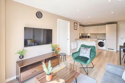 a living room with a large television and a green chair at 2 Bed - Sleeps 6 - Parking - City Centre in Liverpool