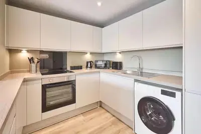 a kitchen with white cabinets and a washing machine at 2 Bed - Sleeps 6 - Parking - City Centre in Liverpool