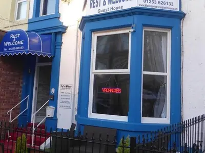 a blue and white building with a sign in a window at Rest and Welcome B&B, Blackpool in Blackpool