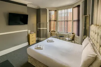 a hotel room with a large bed and a television at Rest and Welcome B&B, Blackpool in Blackpool