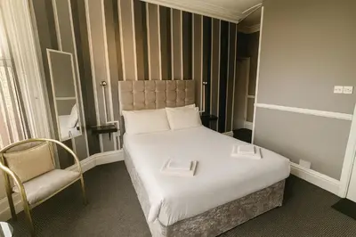 a hotel room with a bed and a chair at Rest and Welcome B&B, Blackpool in Blackpool