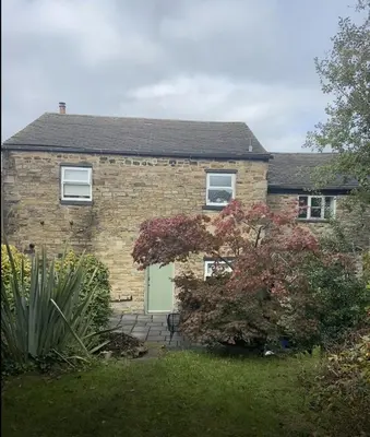a brick house with a green door at Old Store Cottage, Up Holland in Upholland