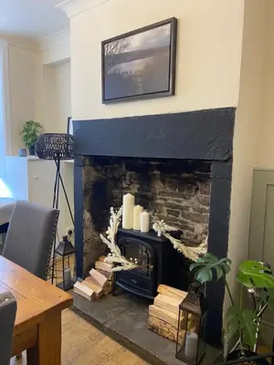 a living room with a fireplace with candles at Old Store Cottage, Up Holland in Upholland
