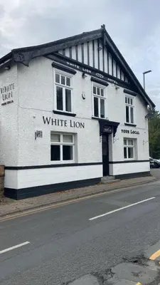 a white building on the side of a street at Old Store Cottage, Up Holland in Upholland