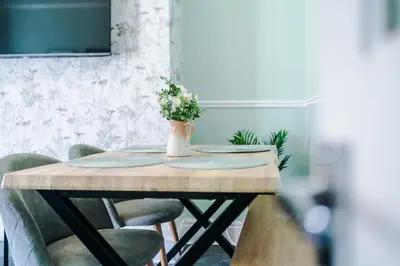 a dining room table with a vase of flowers on it at Skipton House Business Travel Accommodation Parking Liverpool in Liverpool