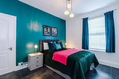 a bedroom with a bed and a green wall at Skipton House Business Travel Accommodation Parking Liverpool in Liverpool