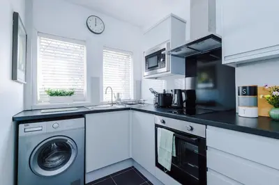 a kitchen with a washer and a sink and a dishwasher at Skipton House Business Travel Accommodation Parking Liverpool in Liverpool