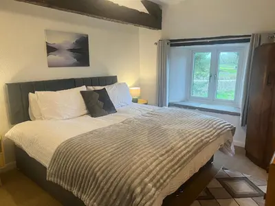 a bedroom with a large bed with a window at The Old Farmhouse at Brackenthwaite Farm in Carnforth