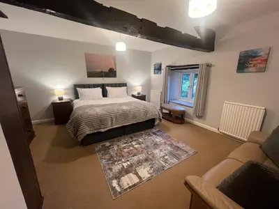 a bedroom with a bed and a living room at The Old Farmhouse at Brackenthwaite Farm in Carnforth