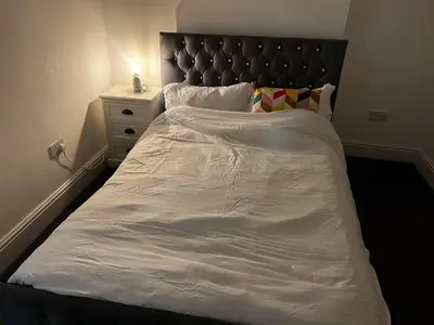 a large white bed with a black headboard in a bedroom at Crosby Marina Apartment in Waterloo