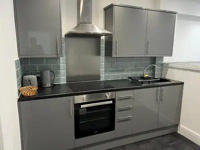 a kitchen with white cabinets and a stove top oven at Crosby Marina Apartment in Waterloo