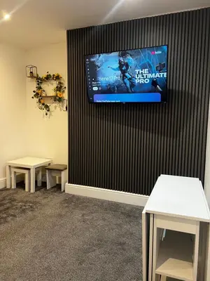 a waiting room with two tables and a tv on the wall at Crosby Marina Apartment in Waterloo