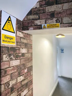 a brick wall with a danger sign on it at The Docklands XL by Serviced Living Liverpool in Liverpool