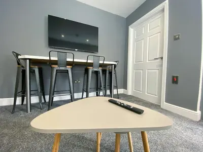 a room with a table with a remote control on it at Full Private House Sleeping Up To 18 - Close To Seafront in Blackpool