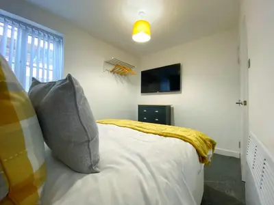 a bedroom with a bed and a tv on the wall at Full Private House Sleeping Up To 18 - Close To Seafront in Blackpool