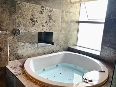 a bath tub in a bathroom with a window at The Luxury Abingdon Apartments - Includes Hot Tub and Jet Bath in Blackpool