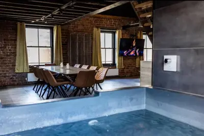 a dining room with a table and chairs and a pool at The Luxury Abingdon Apartments - Includes Hot Tub and Jet Bath in Blackpool