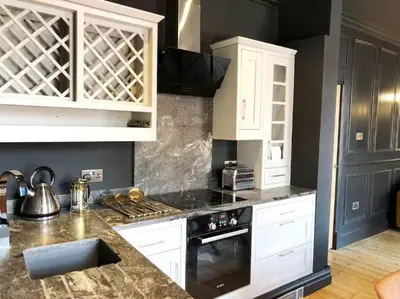 a kitchen with white cabinets and a stove top oven at The Luxury Abingdon Apartments - Includes Hot Tub and Jet Bath in Blackpool