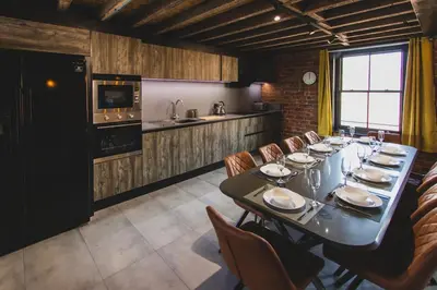 a dining room with a long table and chairs at The Luxury Abingdon Apartments - Includes Hot Tub and Jet Bath in Blackpool